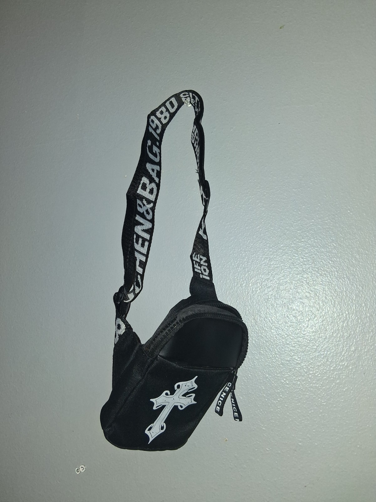 The Black/White Small Crossbody Bag features a bold cross graphic design