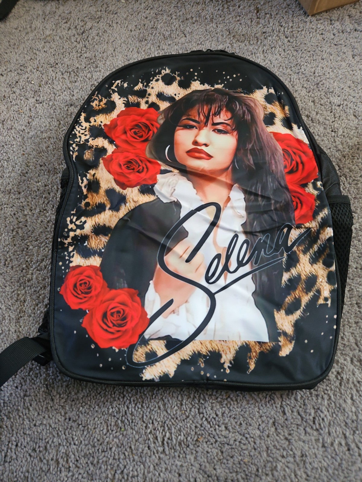singer Selena Quintanilla surrounded by red roses on a leopard-print background.