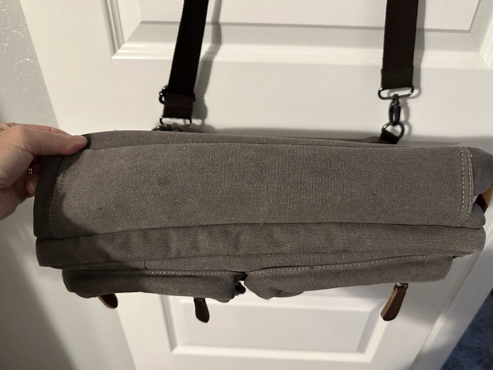 gray canvas messenger bag featuring a leather “SHENG1S” branded