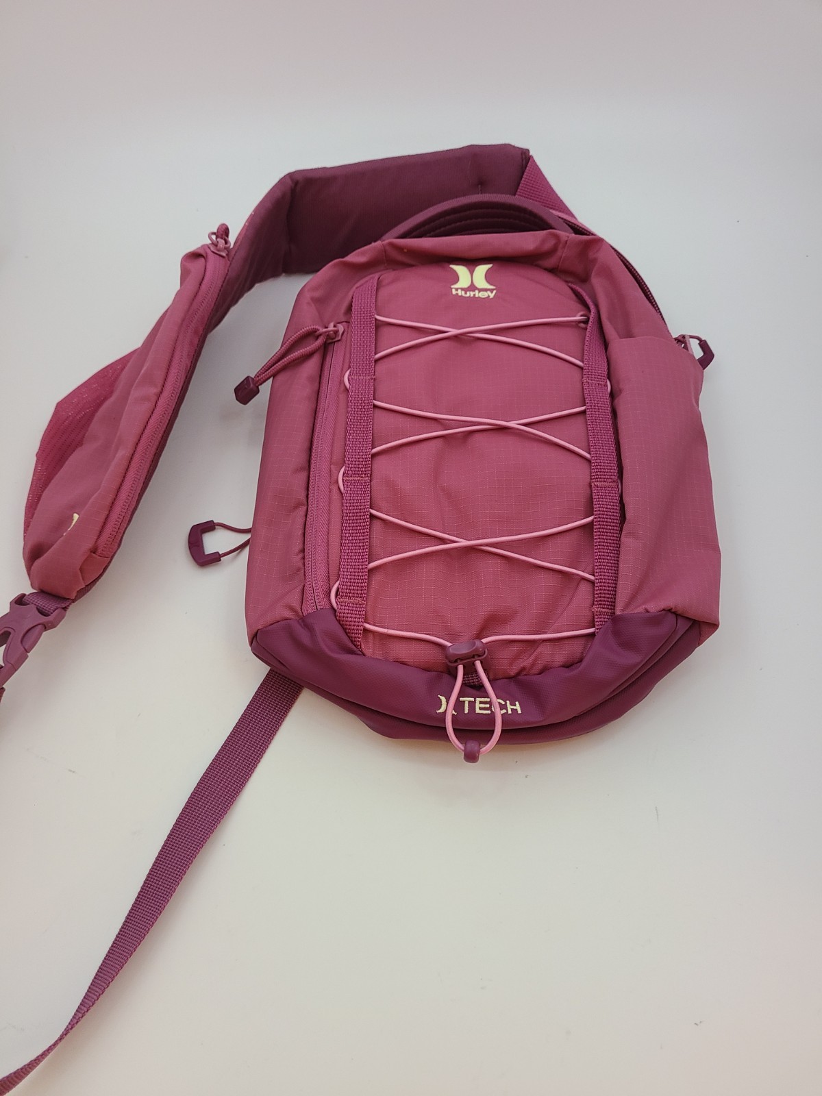 Hurley Terrain Sling Bag Pink features Elastic Bungee Cord System front storage.