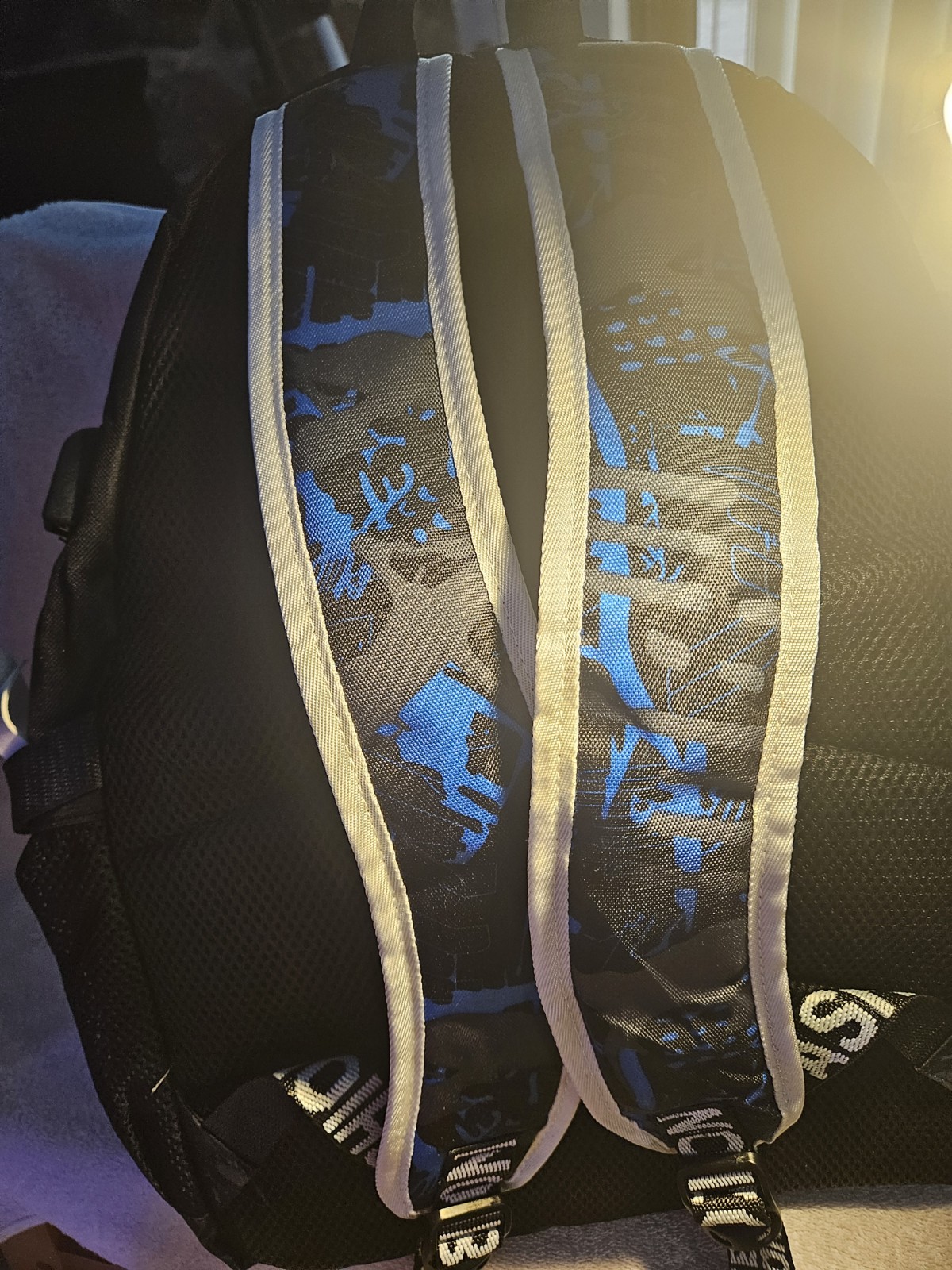 black and blue backpack features a “Senkey Style” luminous graphic of a…