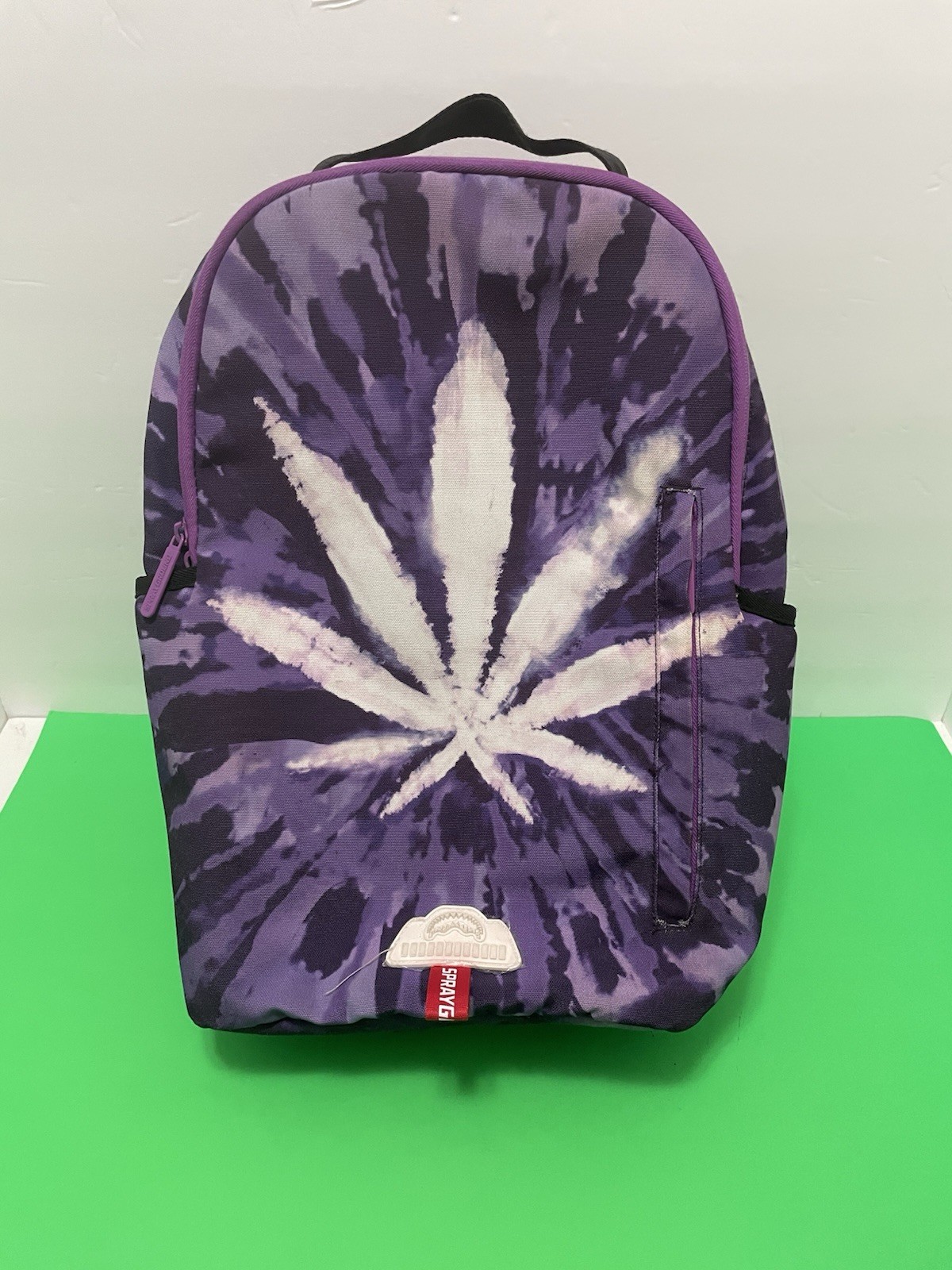 SPRAYGROUND THE JOURNEY BEGINS MARIJAUANA LEAF PURPLE BACKPACK.