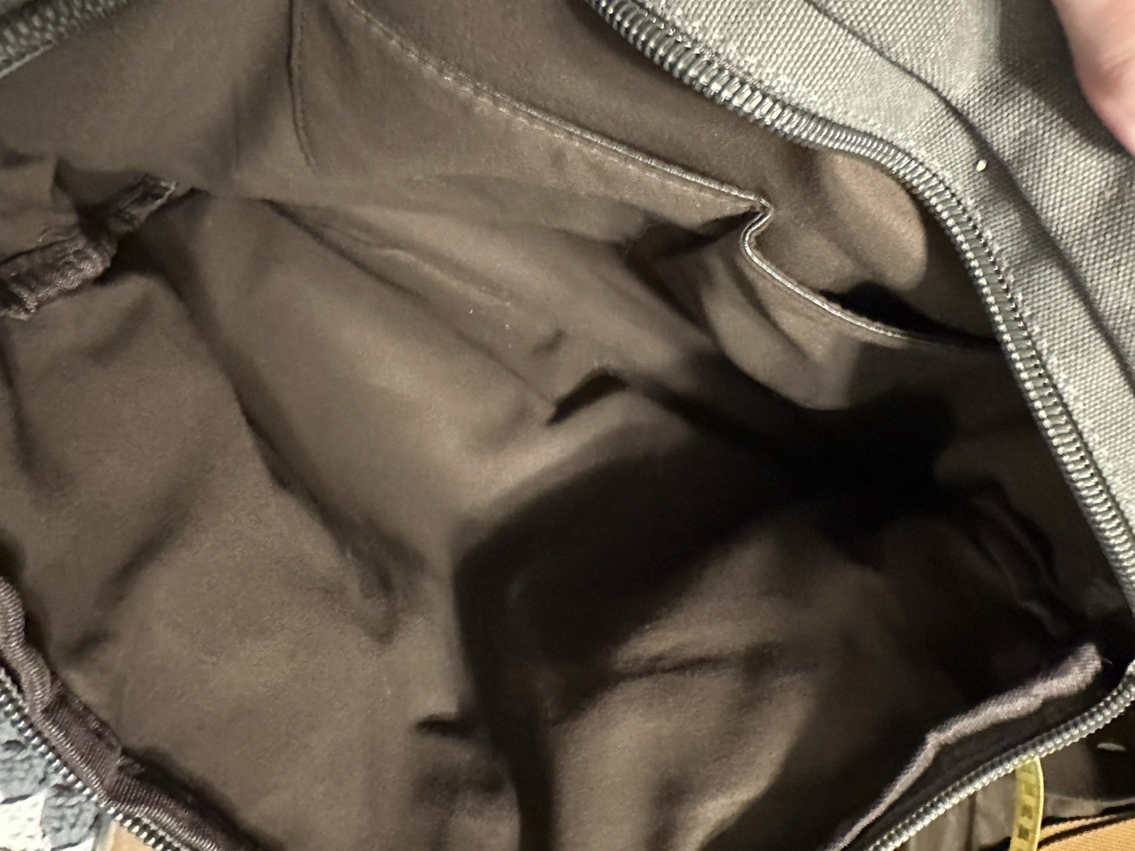 gray canvas messenger bag featuring a leather “SHENG1S” branded