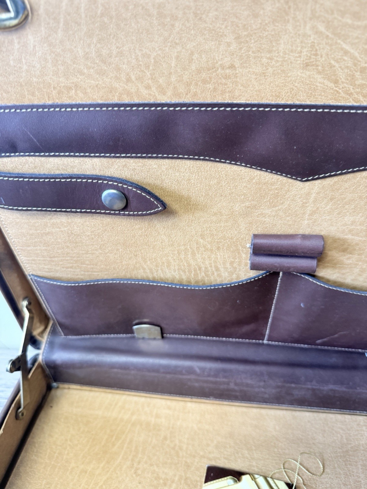 A vintage brown leather briefcase with combination lock and metal hardware.